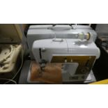 A Cased Electric Singer Sewing Machine with Power Leads, Instructions etc