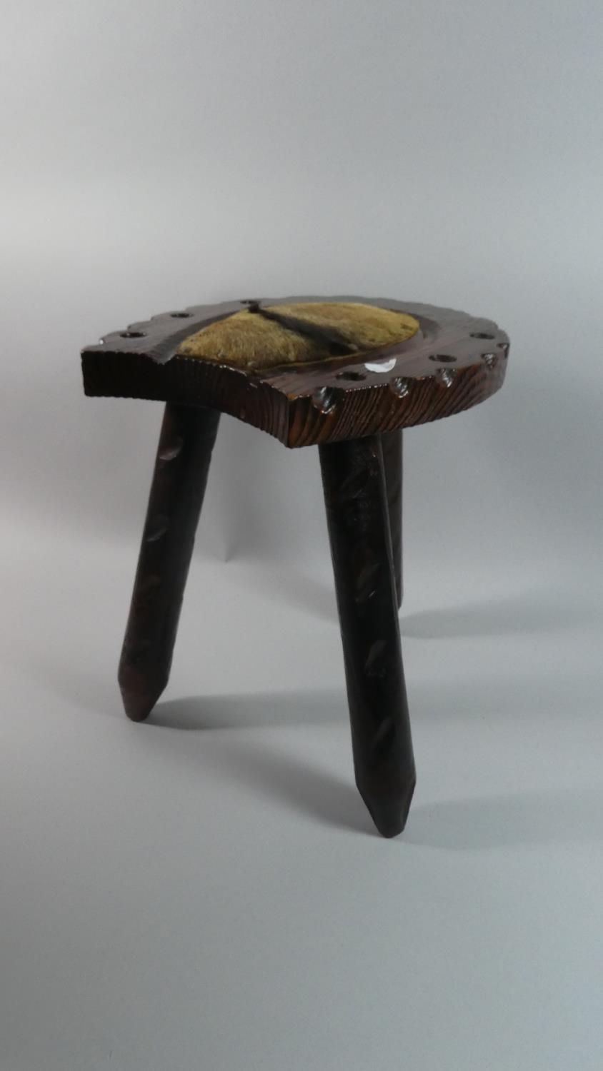 A Stained Wooden Horseshoe Shaped Stool with Three Legs and Animal Skin Panel, 36cm Long