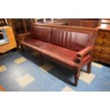 A Long Mahogany Framed Pub Bench with Red Leather Upholstery, 220cm Wide