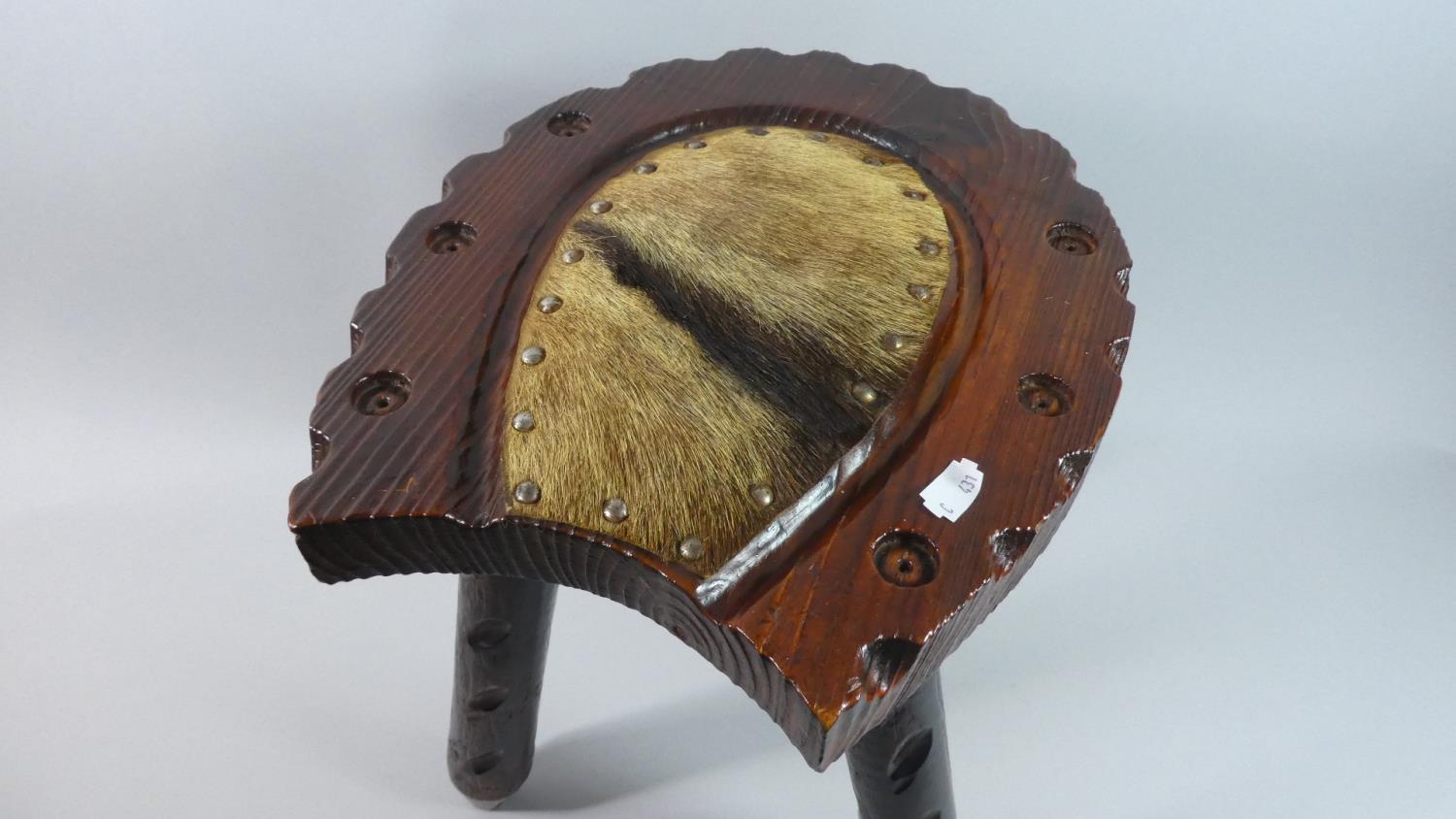 A Stained Wooden Horseshoe Shaped Stool with Three Legs and Animal Skin Panel, 36cm Long - Image 2 of 2