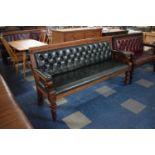 A Mahogany Framed Green Leather Buttoned Upholstered Pub Settle with Scrolled Arm Rest Supports,