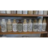 A Collection of Nine Stoneware Bottles with Printed Bottle for Stones Ginger Beer, R Clayton
