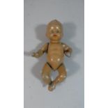 A Small Vintage Painted Metal Baby Doll with Jointed Arms and Legs, 11.5cms Long