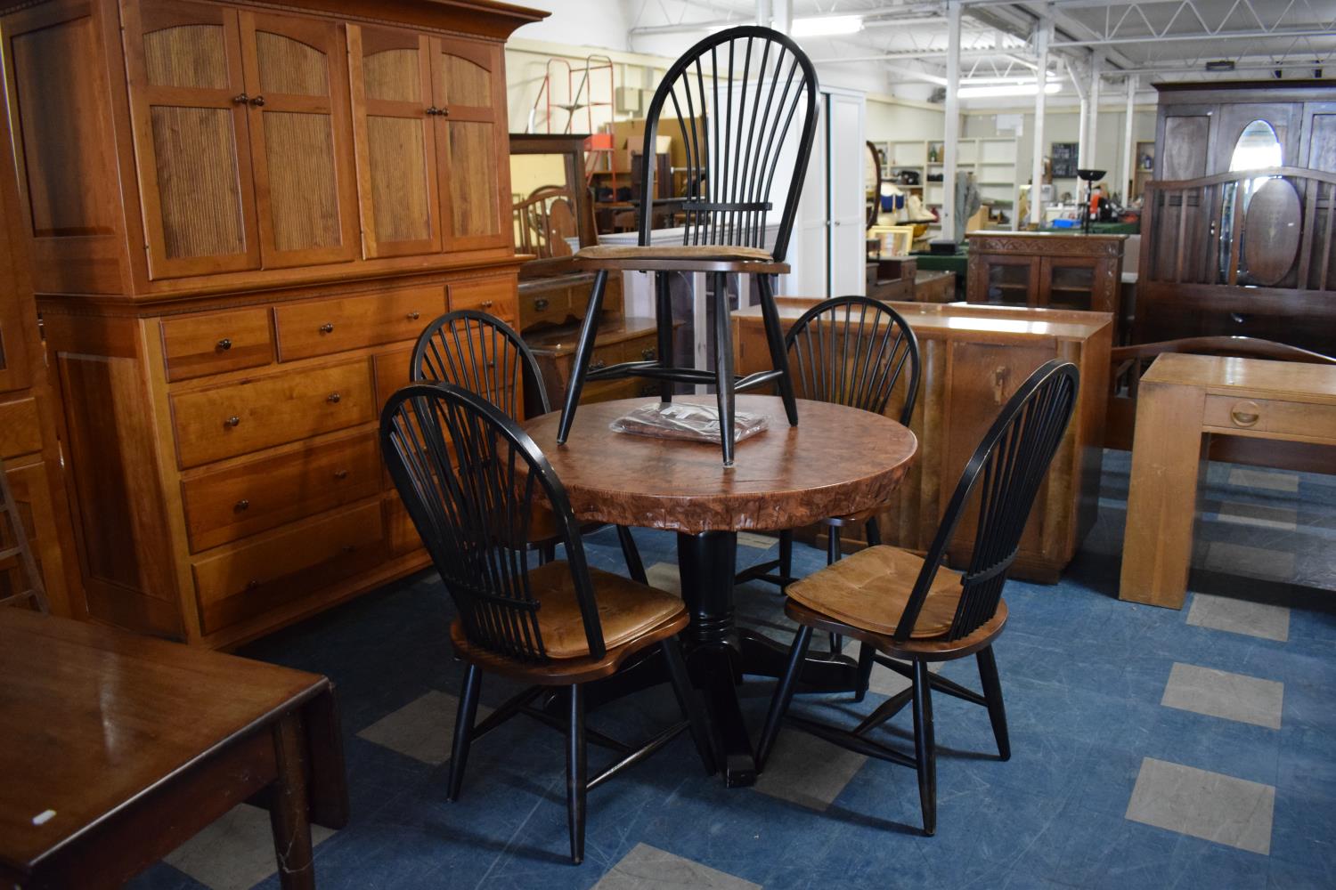 A Modern Circular Black Painted Dining Table and Five Maple Spindle Back Dining Chairs and Two