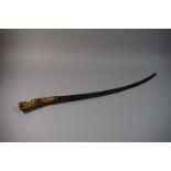 A Long Curved Bladed Ceremonial Carving Knife with Carved Antler Handle Decorated in Relief with