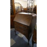 An Edwardian Fall Front Bureau with Fitted Interior, Three Long Drawers and Cabriole Supports with