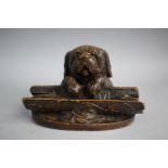 A Carved Black Forest Novelty Desk Top Pen Rest and Inkwell in the Form of a Puppy with Glass Eyes