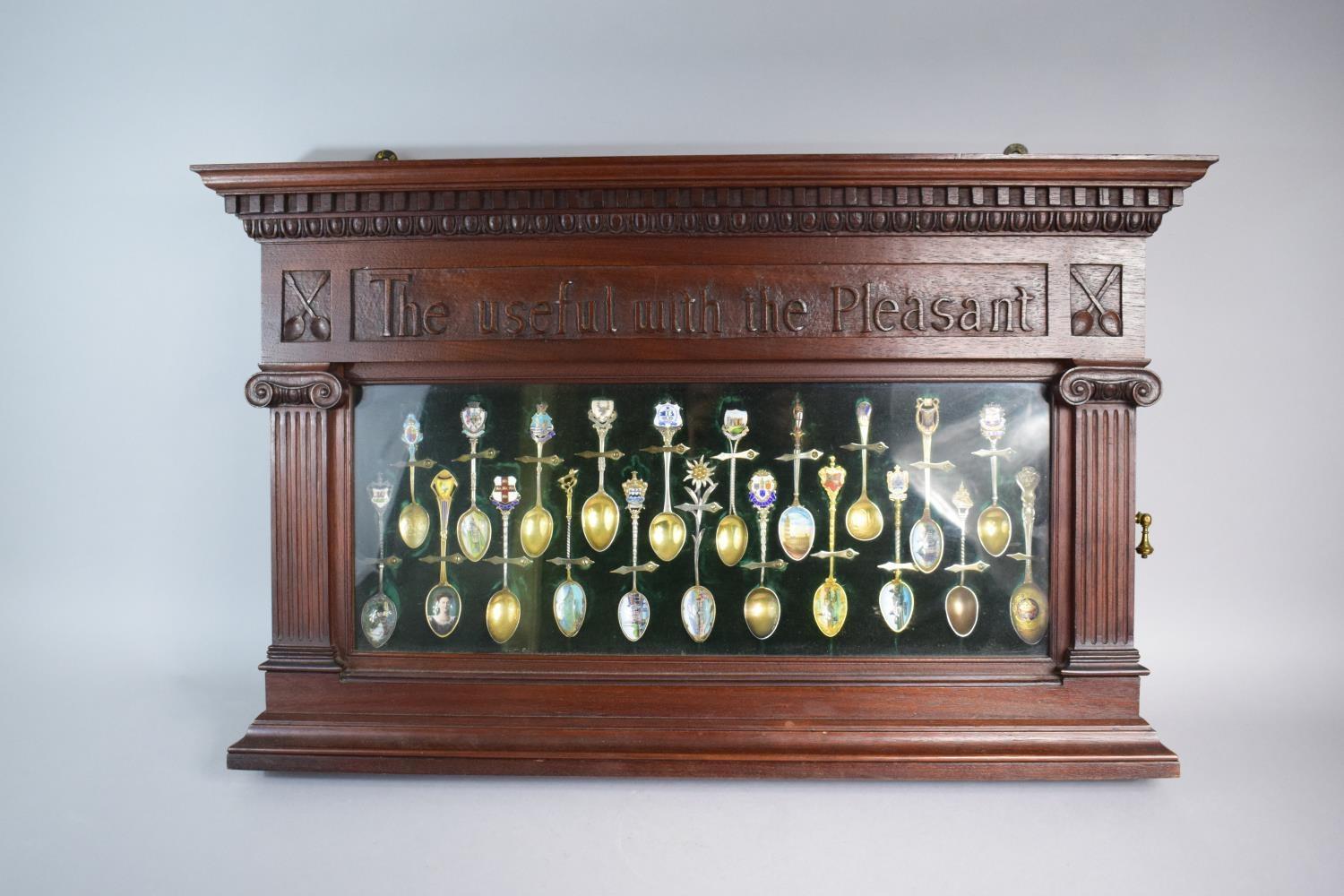 A Late 19th Century Mahogany Wall Hanging Display Containing 21 Enamelled Silver Souvenir Spoons.