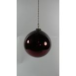 A 19th Century Cranberry Glass Witches Ball Suspended From Metal Chain. 18cm diameter