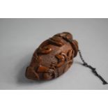 A Carved Prisoner of War Coquilla Nut Snuff Bottle with Hounds, Weapons and Bound Heart. 6.5cms Long