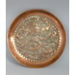 An Arts and Crafts Style Copper Dish decorated in relief with Birds and Foliage. 22cms Diameter