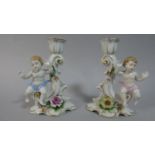 A Pair of Continental Figural Candlesticks with Cherub, Floral Encrusted Decoration and Scrolled