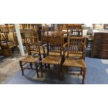 A Harlequin Set of Six Rush Seated Spindle Back Dining Chairs to Include Two Carvers