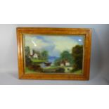 A Victorian Maple Framed Painting on Glass Depicting Lake Scene with Church Cottage and Figure in