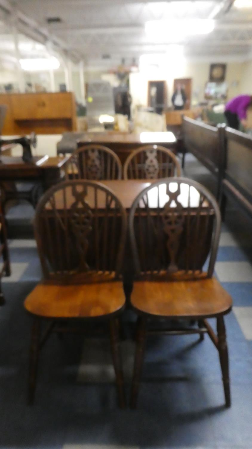 A Mid 20th Century Oak Drop Leaf Dining Table and Four Wheel Back Chairs