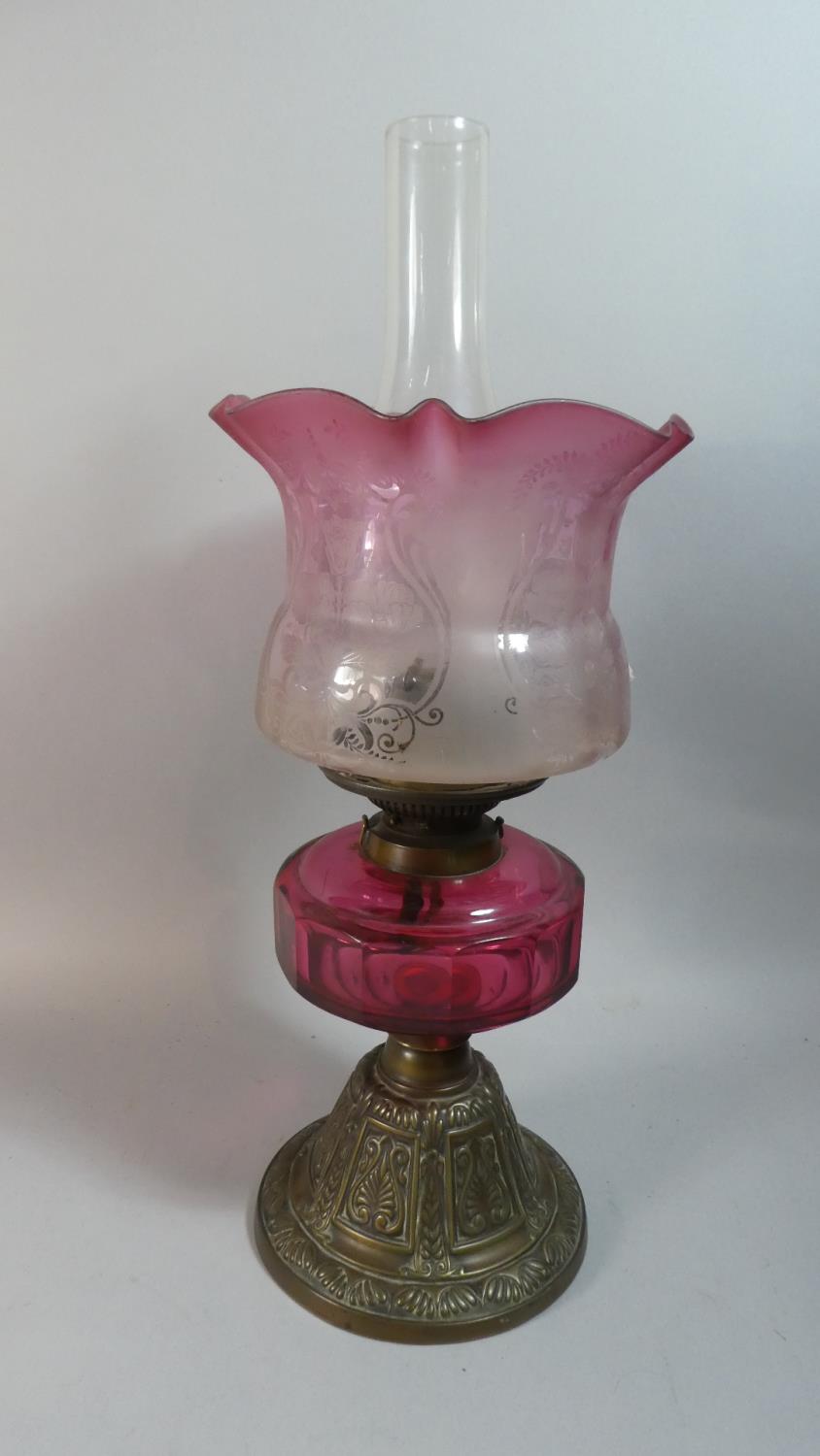 A Late Victorian Brass Based Oil Lamp With Cranberry Glass Reservoir, Hinks Duplex Controls and