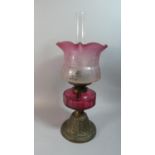 A Late Victorian Brass Based Oil Lamp With Cranberry Glass Reservoir, Hinks Duplex Controls and