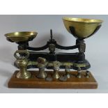 A Pair of Black Painted Kitchen Scales with Brass Pans Together with a Set of Graduated Bell Weights