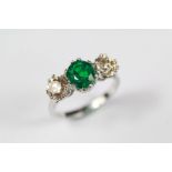 An 18ct White Gold Emerald and Diamond Three-stone Ring