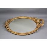An Oval Carved Gilt Wood and Plaster Mirror