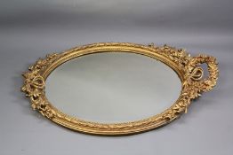 An Oval Carved Gilt Wood and Plaster Mirror