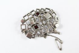 A Silver and Garnet Modernist Brooch