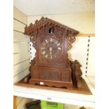 A CARVED OAK CUCKOO CLOCK WITH FRETWORK DECORATION (SOME MISSING) AND BACK DOOR WITH GONG +