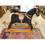 A ROCKING HORSE ON A PINE BASE