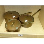 A SET OF THREE BRASS HANDLED COPPER FINISH SAUCEPANS