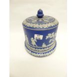 A BLUE AND WHITE JASPERWARE STILTON CHEESE DISH AND COVER WITH RAISED , CHERUB AND ANGEL CLASSICAL