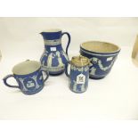 A WEDGWOOD BLUE AND WHITE JASPERWARE JUG TOGETHER WITH ANOTHER TWO JUGS AND A JARDINIERE - ALL