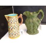 A GREEN SALT GLAZE BACCHUS JUG AND A MAJOLICA JUG