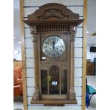 A MAHOGANY WALL CLOCK WITH GLAZED PANELS AND SILVERED DIAL