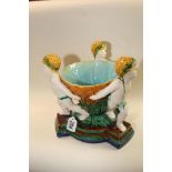 AN EARLY 20TH CENTURY MAJOLICA CENTERPIECE WITH THREE CHERUBS HOLDING A DISH, 28CM HIGH BY 25CMS