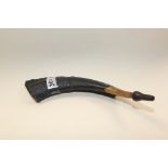 A PIECE OF ANIMAL HORN WITH MOUTHPIECE FITTED AND INDISTINCTLY SIGNED
