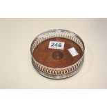 A SILVER WINE BOTTLE COASTER WITH WOODEN BASE, HALLMARKED LONDON 1985 BY C J VANDER LTD, 13CM