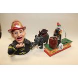THREE CAST IRON MONEY BOXES, ONE DEPICTING A FIREMAN THE OTHER CIRCUS TRICK DOG