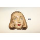 AN ART DECO CERAMIC WALL PLAQUE DEPICTING A LADY'S FACE, 22.5CM LONG