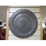 AN ANTIQUE MIDDLE EASTERN PEWTER HAND HAMMERED CHARGER WITH COPPER DETAILING, 49CM IN DIAMETER