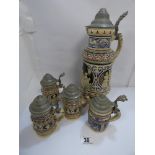 FIVE EARLY 20TH CENTURY CERAMIC GERMAN BEER STEINS IN VARIOUS SIZES