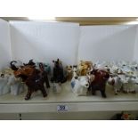 AN EXTENSIVE COLLECTION OF CERAMIC COW CREAMERS IN A VARIETY OF SHAPES AND SIZES