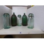 THREE LIDDED GLASS STORAGE CONTAINERS AND TWO GLASS BOTTLES WITH MESH LINER TO THE OUTSIDE