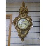 A GILT WOOD WALL CLOCK WITH ENGRAVED FLORAL AND FOLIATE DECORATION, 66CM BY 36CM WIDE