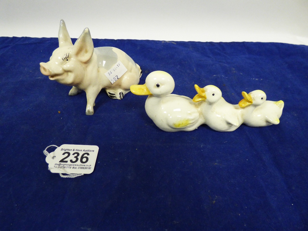 A BESWICK FIGURE OF A SEATED PIG, NO 832, TOGETHER WITH ANOTHER BESWICK FIGURE OF THREE DUCKS