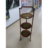 AN EDWARDIAN MAHOGANY FOLDING THREE TIER CAKE STAND, 91CM HIGH (HANDLE AF)