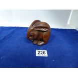 A CHINESE CARVED WOODEN FIGURE OF A RABBIT, ENGRAVED CHARACTER MARK TO BASE, 9CM HIGH