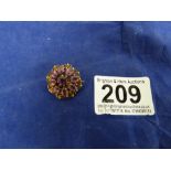 A 9CT GOLD BROOCH WITH A CENTRALLY SET BLUE STONE SURROUNDED BY EIGHT PINK STONES, 2G