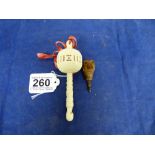 A CARVED BONE BABIES RATTLE AND WHISTLE, 12.5CM LONG, TOGETHER WITH A CARVED WOODEN DOGS HEAD WITH