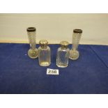 A PAIR OF SILVER TOPPED GLASS TOILETRIES BOTTLES AND A PAIR OF SIMILAR SILVER TOPPED GLASS SPILL