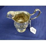 A GEORGE III SILVER CREAM JUG OF BALUSTER FORM, HEAVILY EMBOSSED DECORATION THROUGHOUT, HALLMARKED